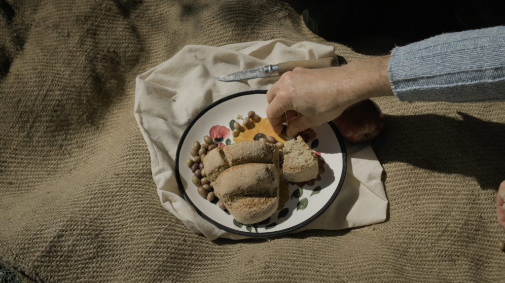 Cinematic frame from a travel film in Agios Nikolaos Crete by The Film Tailors, featuring a traveler experiencing the region across seasons